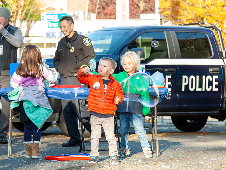 Children play in front of a police truck on display at a Bright Horizons fundraiser for a domestic violence shelter.