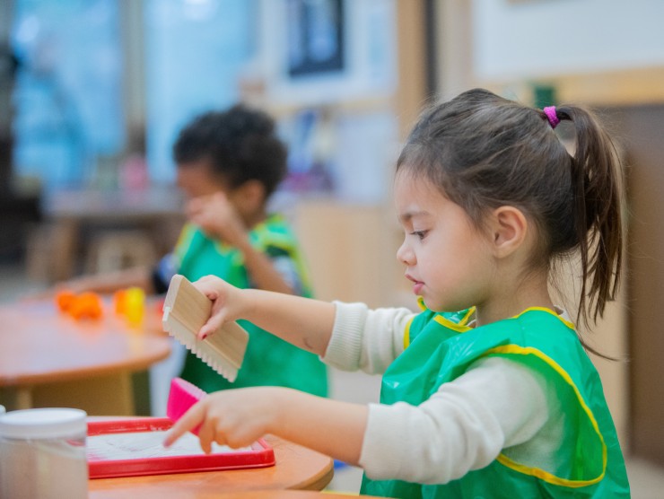 child at table playing arts and crafts 