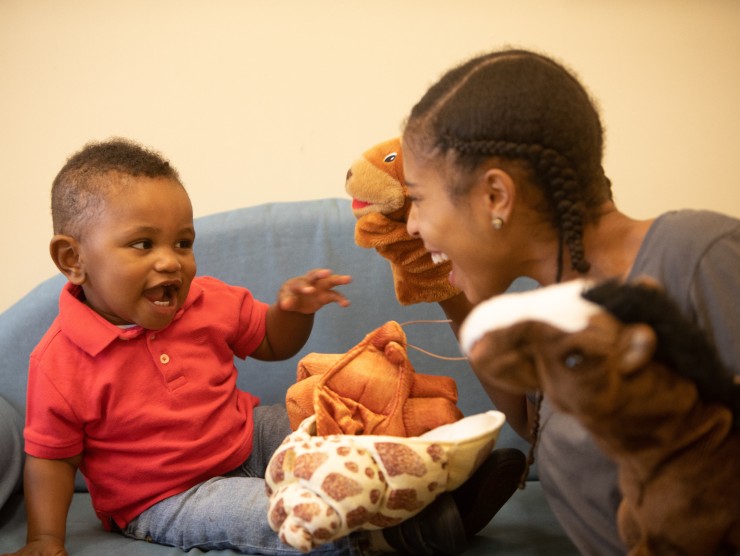 teacher and child playing with puppets