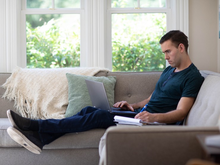 mad sitting on couch with laptop 