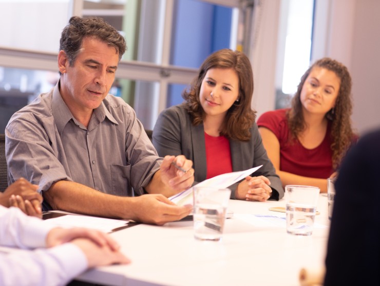 co-workers sitting around table talking 