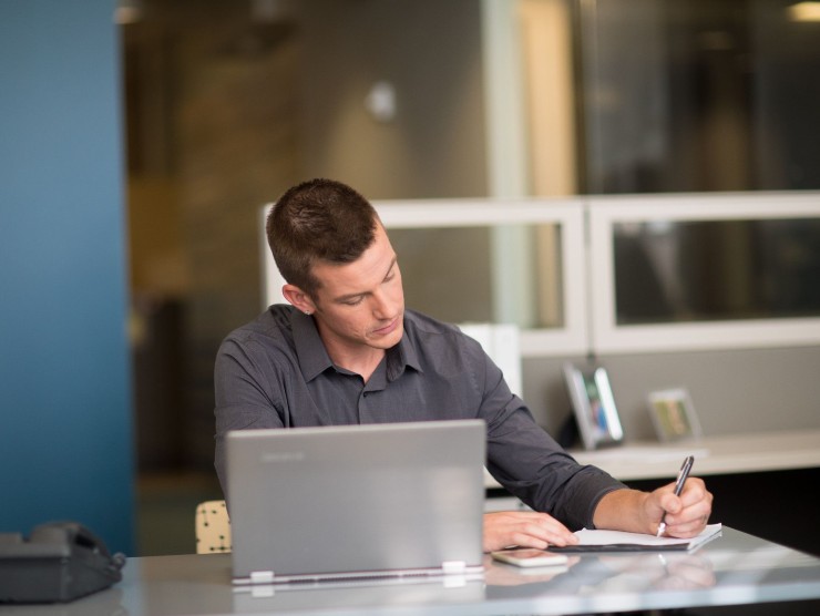 man sitting at table with laptop 