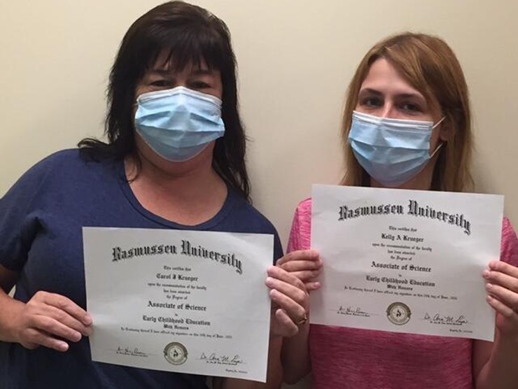 mother and daughter standing with diplomas 