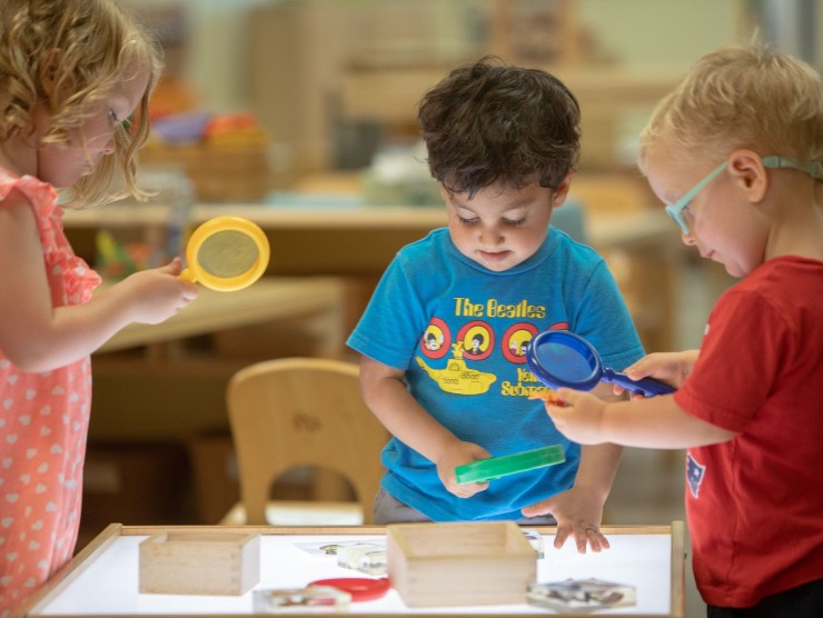 children standing around table playing 