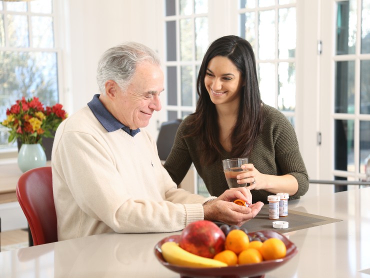 elderly man sitting with caretaker