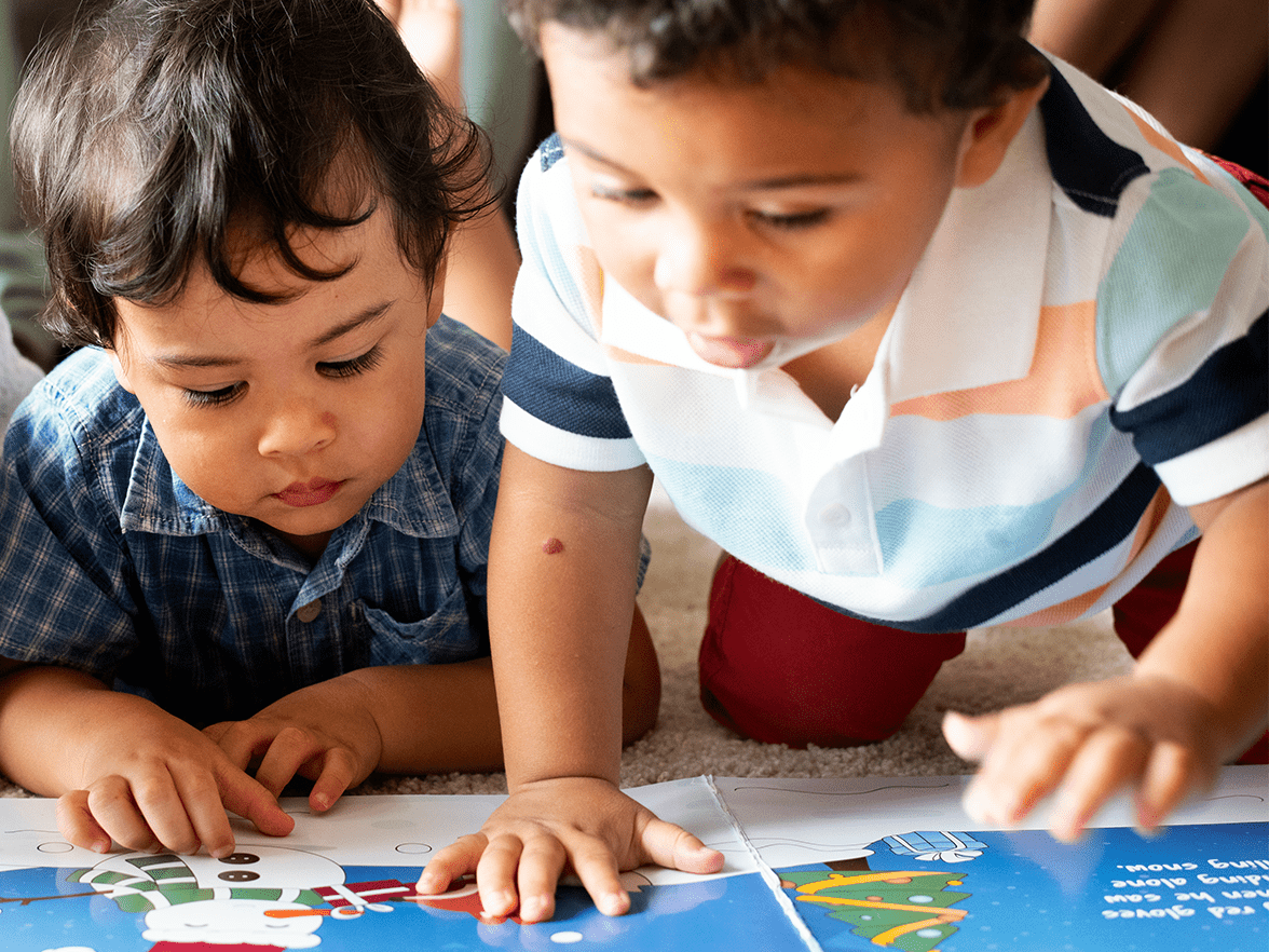 Two young children looking at a book