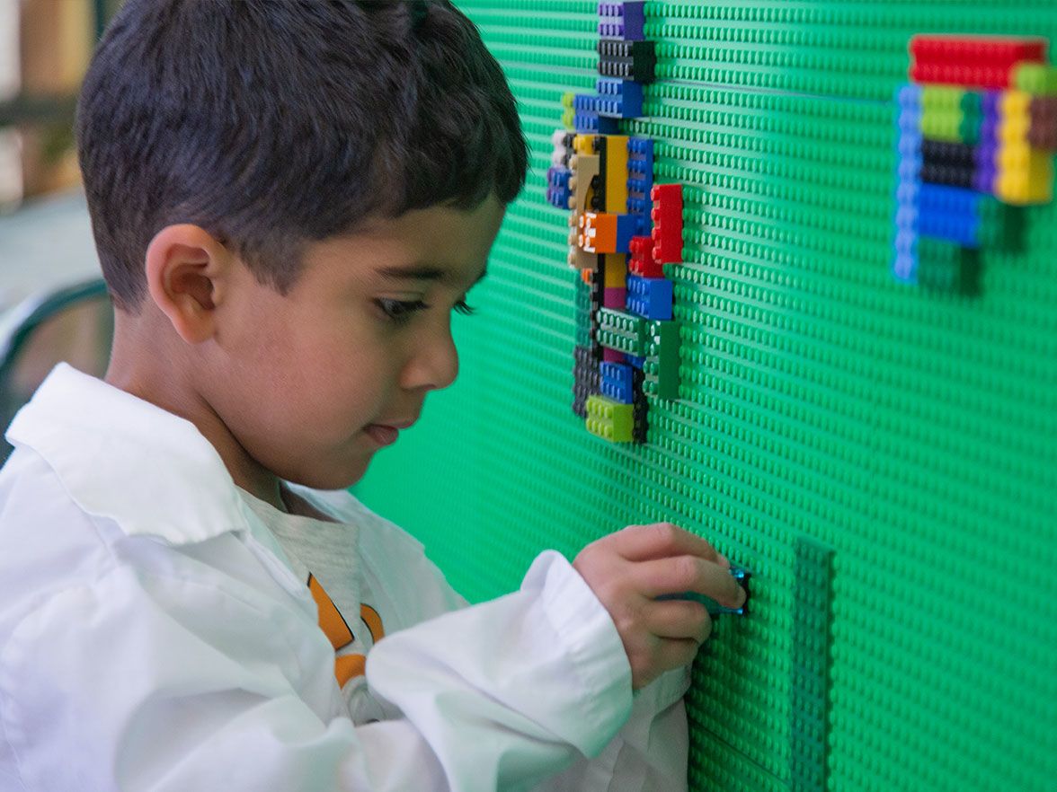 Young boy plays with legos in daycare