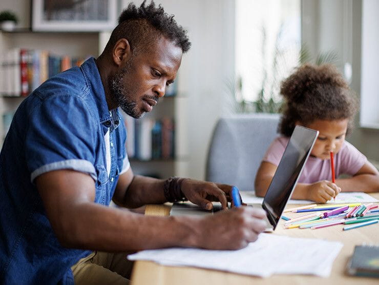 Father and daughter working together at the kitchen table