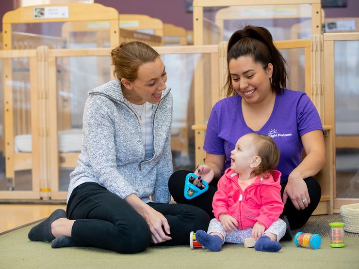 Mom and teacher playing with a child on the floor