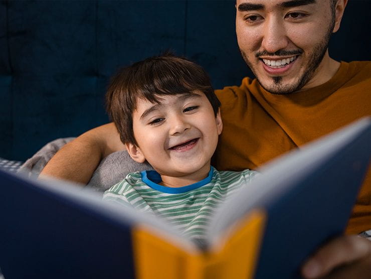 Father and son reading a book together