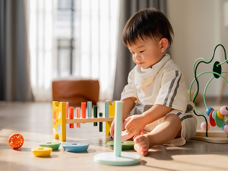 Toddler playing with toys on the floor
