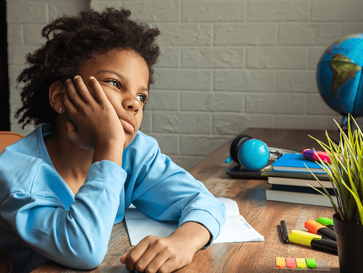 Student sitting at a desk full of books