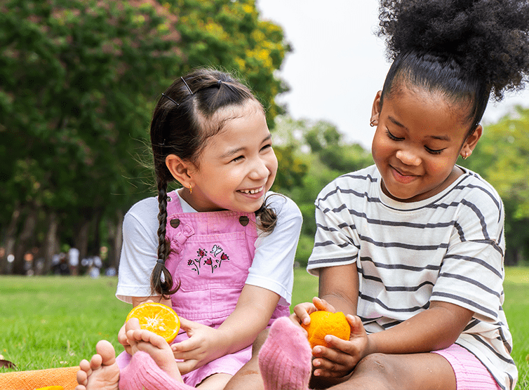 Young girls eating snacks in the park