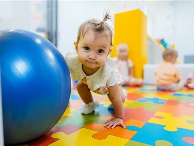 Young child playing with an exercise ball in a center