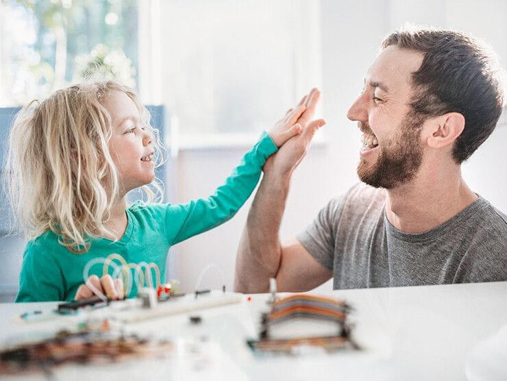 Father and daughter high fiving