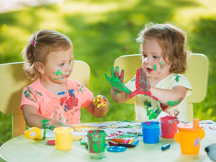 Toddler finger painting outside