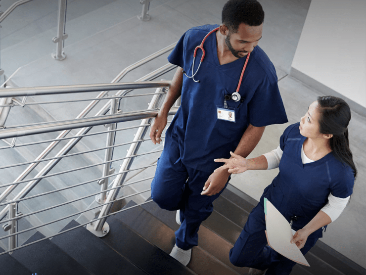 Two doctors having a conversation as they walk up stairs