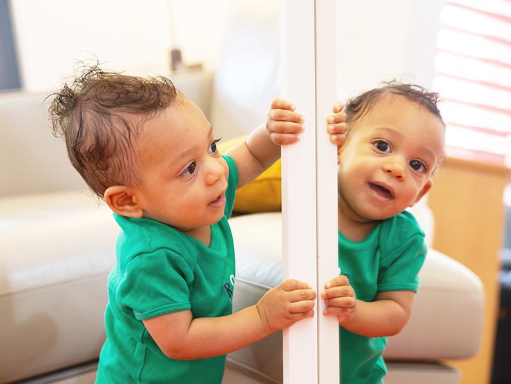 Toddler playing with a mirror