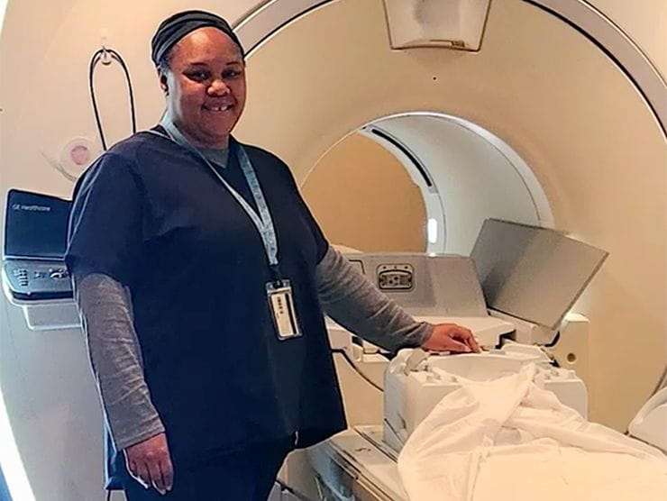 Nurse standing next to a medical machine