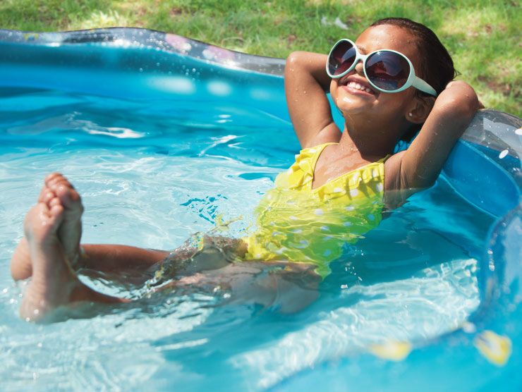 Girl sun tanning in a small pool