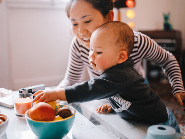 A mother and her baby sitting at a table together