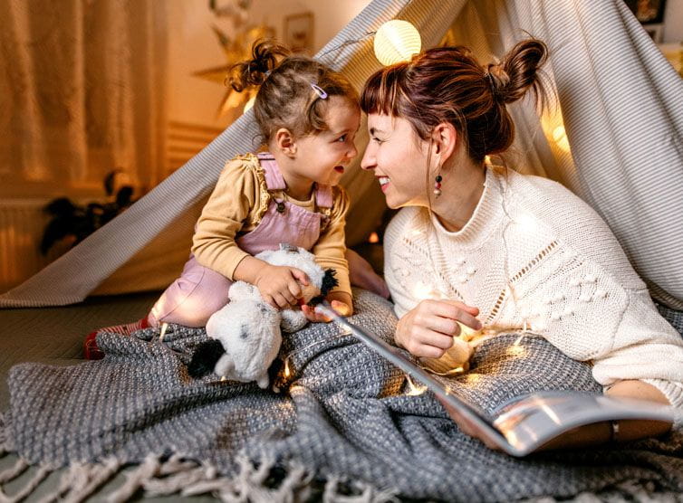 Mother and daughter playing in a tent