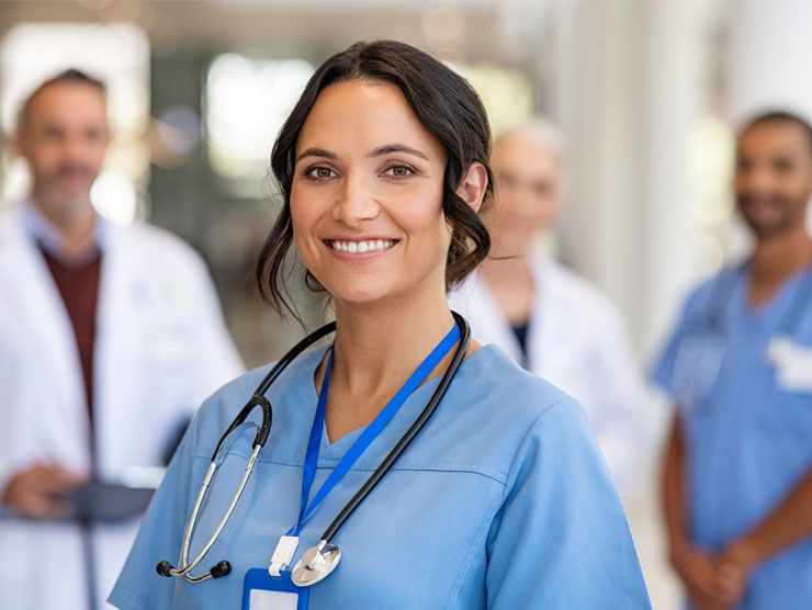 A female doctor smiling with medical staff standing in the background