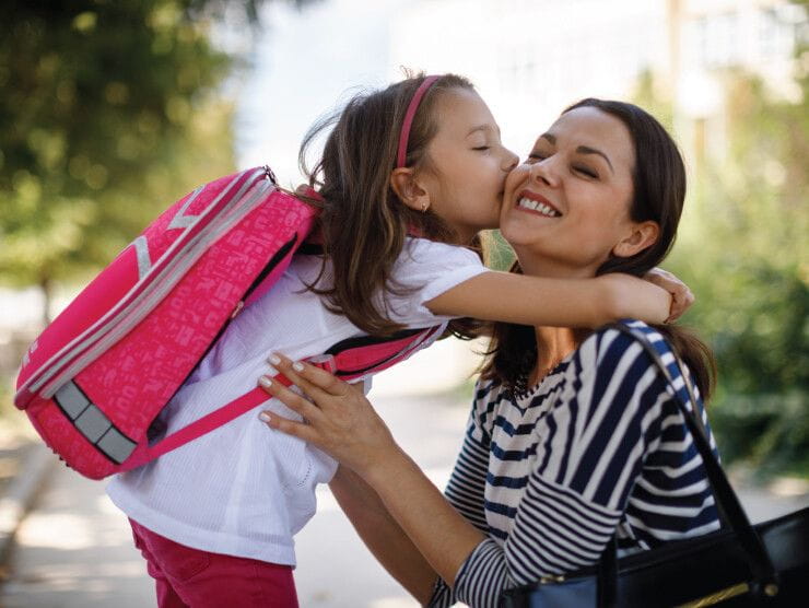 Mother and daughter hugging before leaving for school