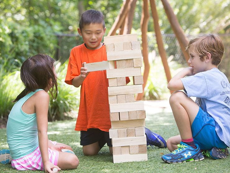 School-aged children playing outside with blocks