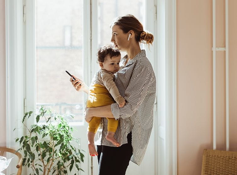 Woman on the phone holding a child