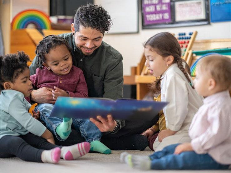 Teacher reading a book with students