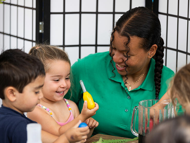 A teacher and students working on arts & crafts