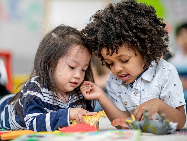 Two kindergarten students playing with toys in a classroom