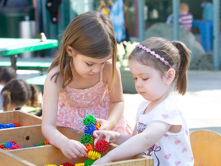 Two young girls playing with toys