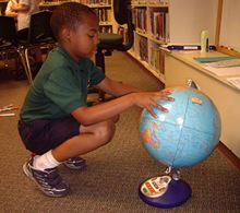 A child studying a globe
