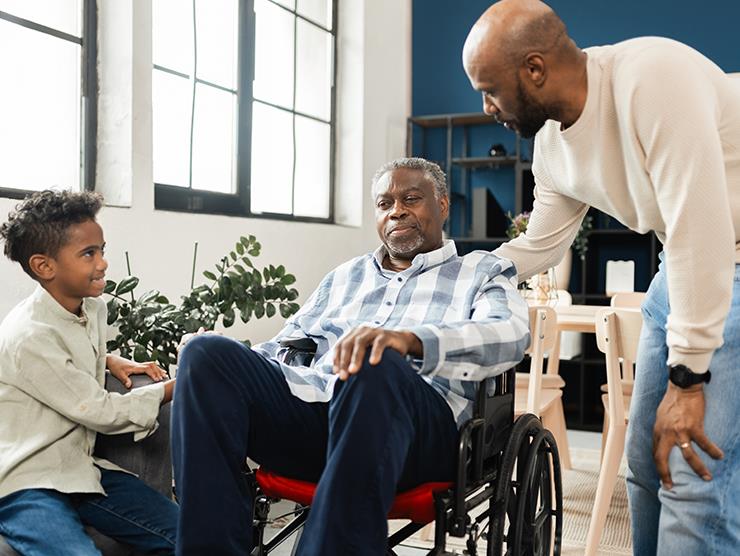 A young boy and his father talking to an elderly grandparent.
