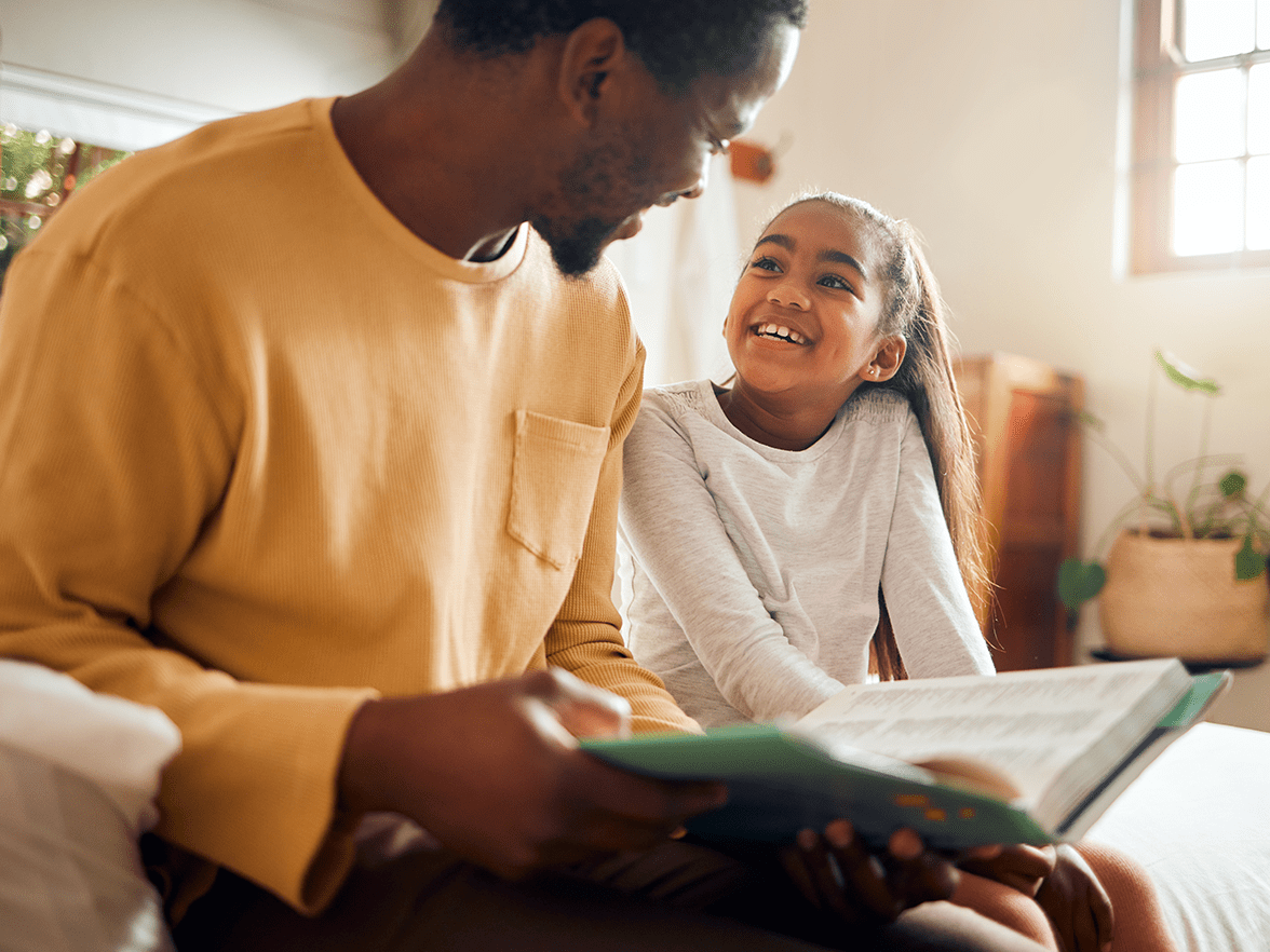 A father reading to his daughter. 
