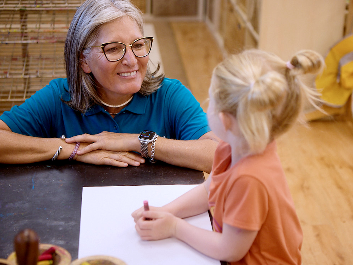 Teacher with a child who is drawing
