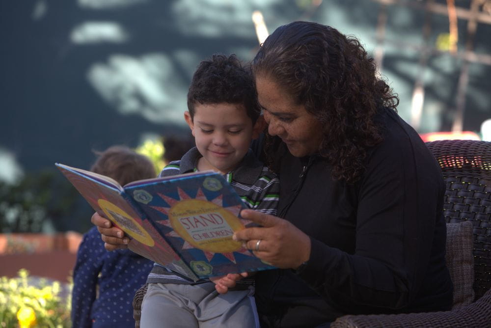 A mother reading to a young boy. 