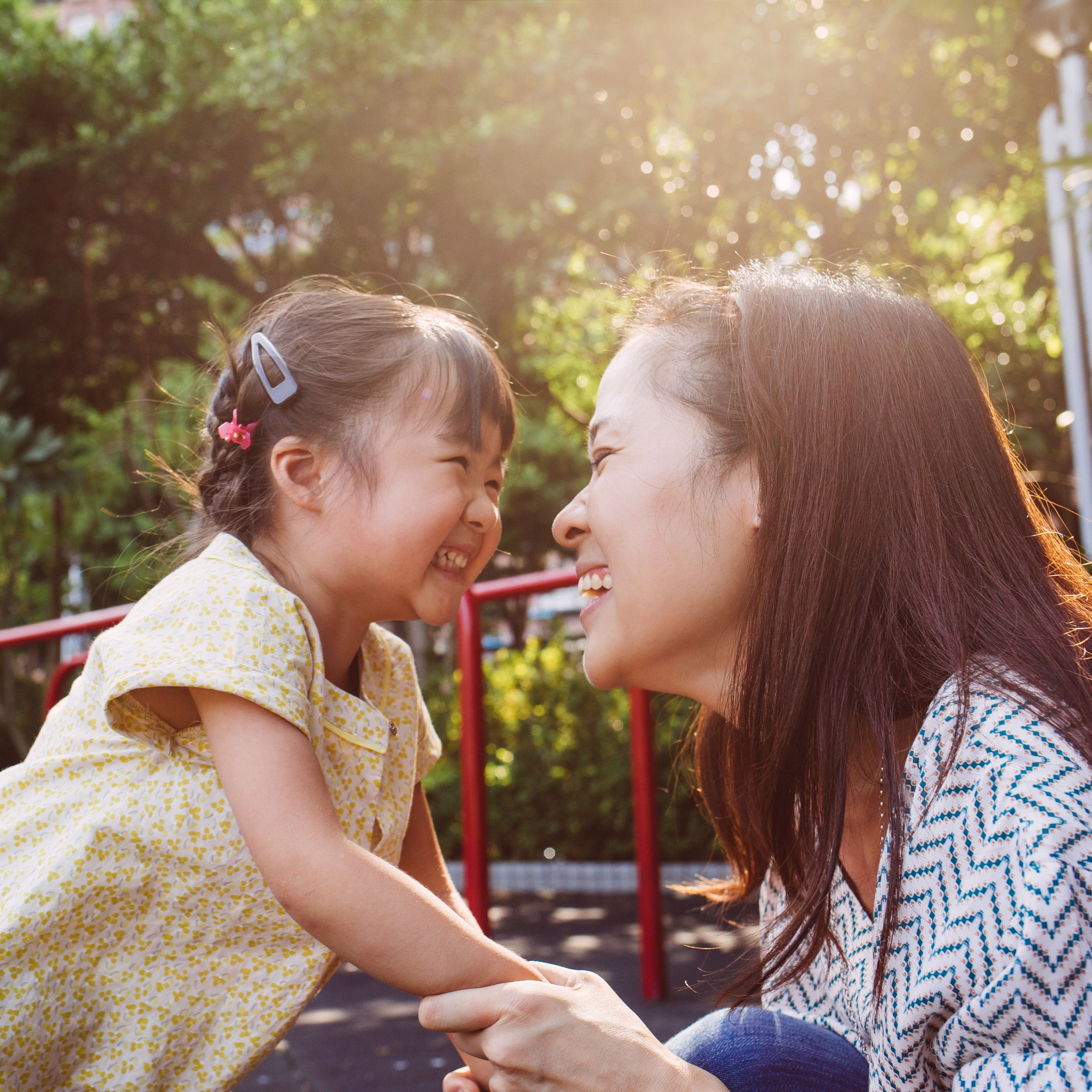 Woman and toddler girl smiling outside