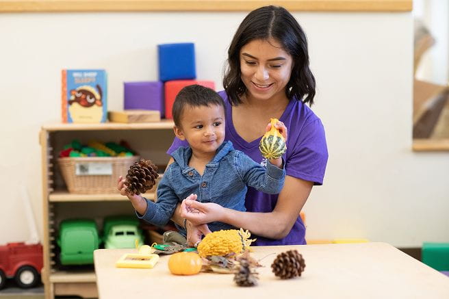 A woman playing with a child in a daycare center