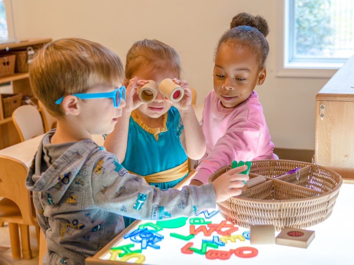 3 children playing in a classroom. 