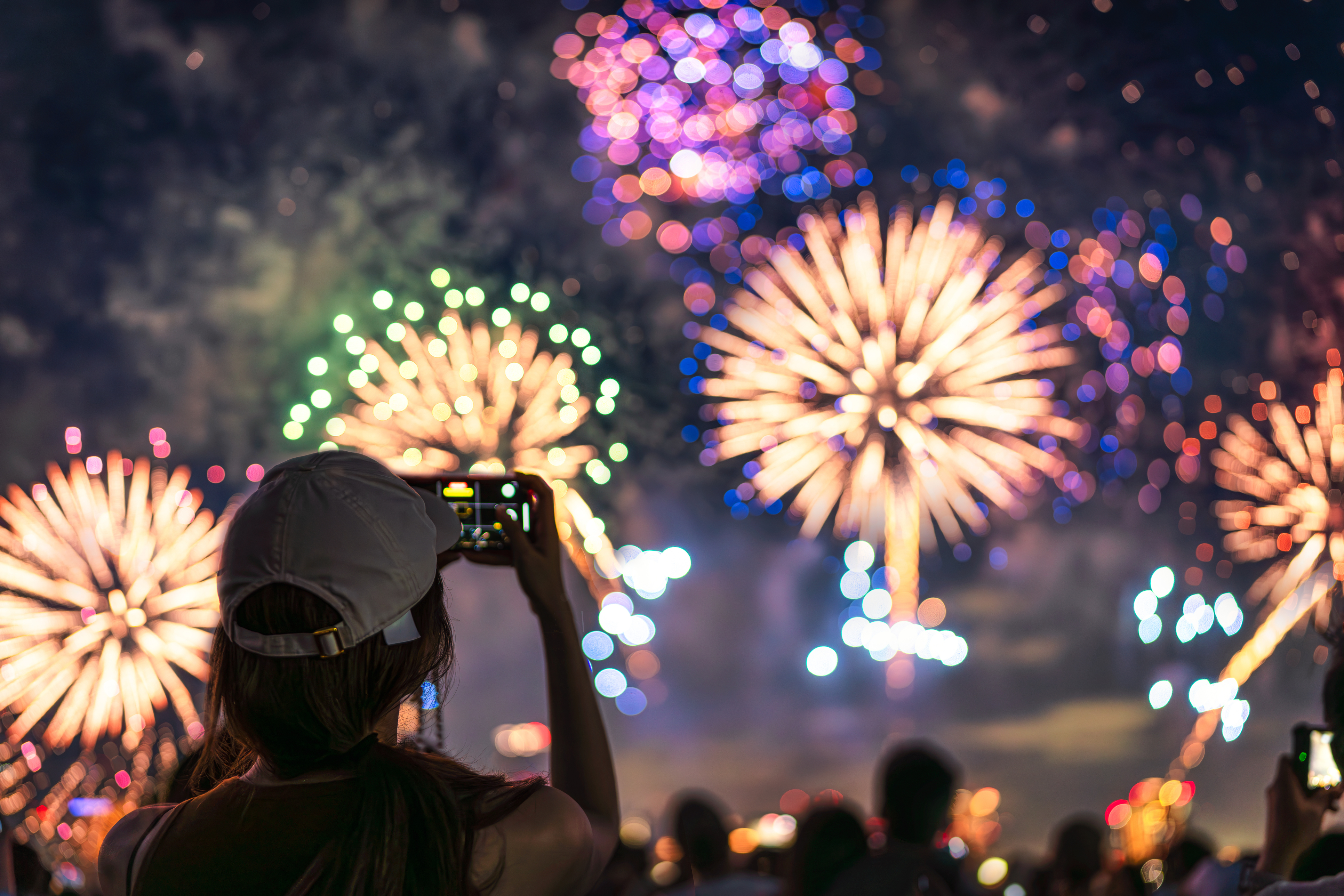 woman taking picture of fireworks display