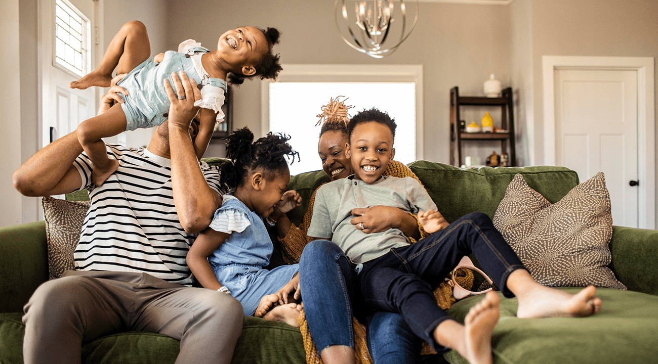 A family playing on the couch. 