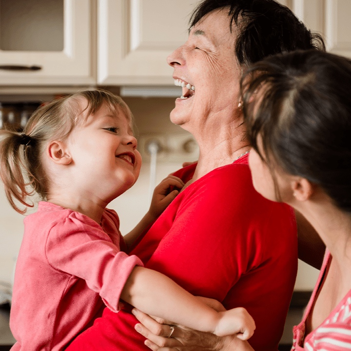 A woman and two girls laughing. 