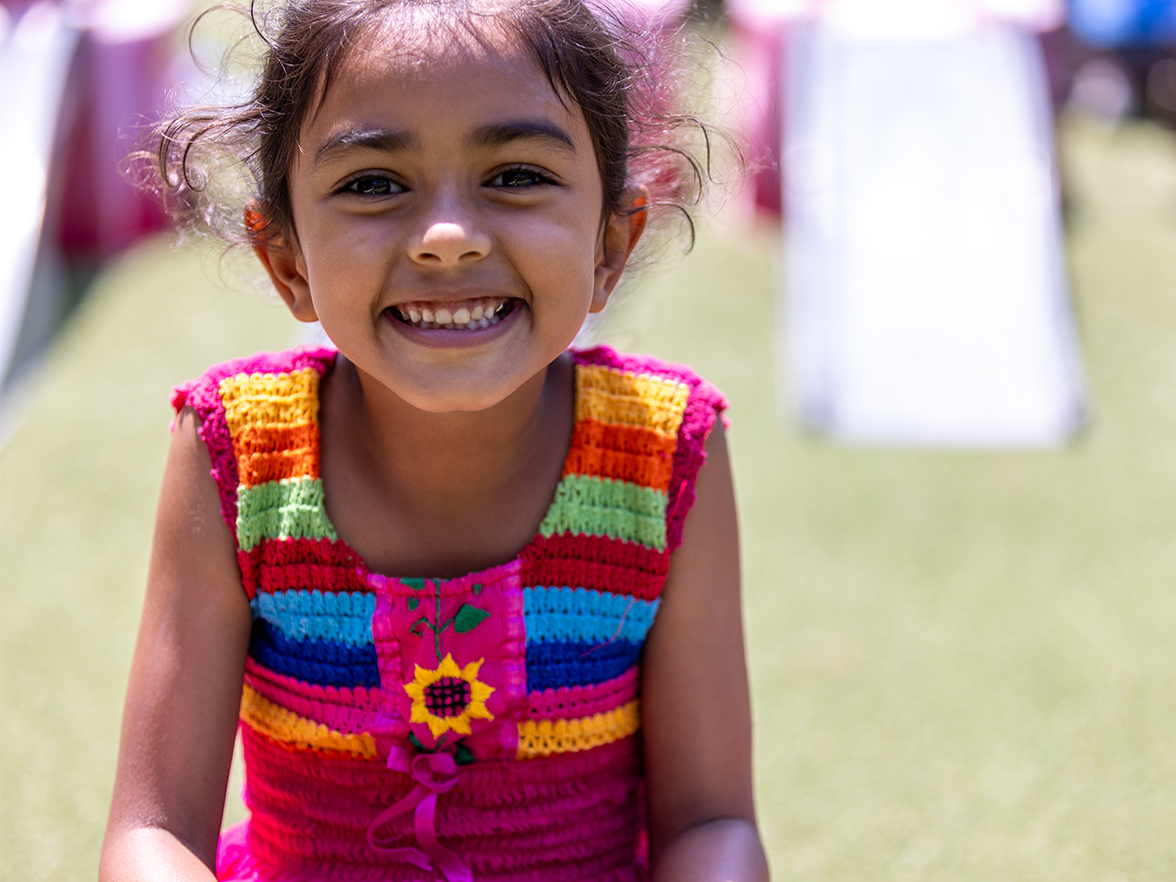 School age girl smiling while playing outside