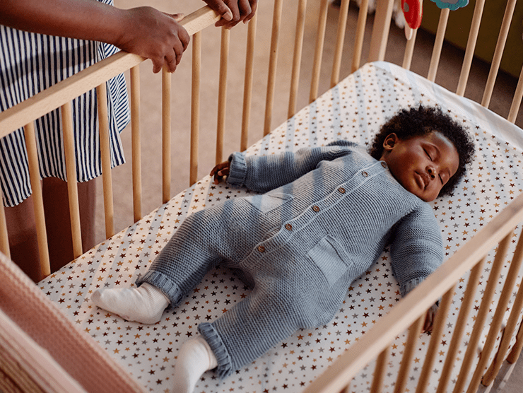 An infant sleeping in a crib