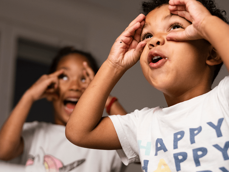 Two young boys pretending to hold binoculars 