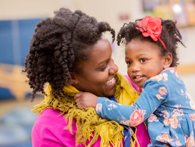 mom and daughter embracing at child care center
