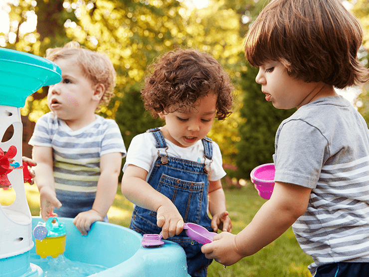 Three toddlers playing outside. 